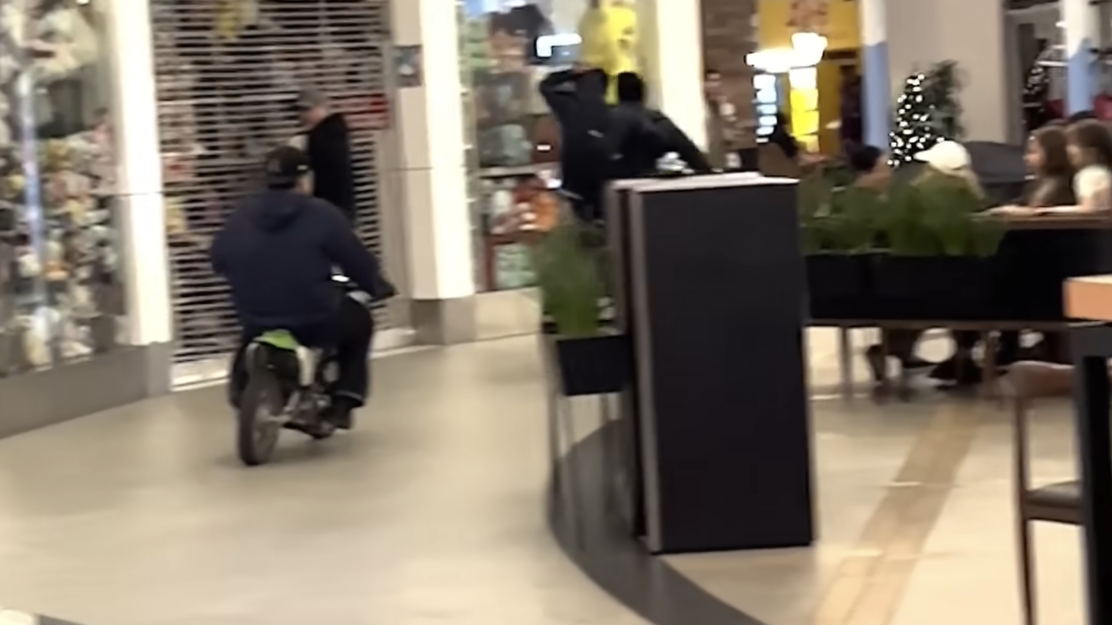 Dirt bikes ride through a busy shopping mall